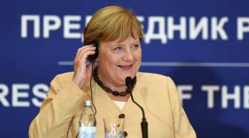 По Берлину развесили плакаты с фирменным жестом Меркель