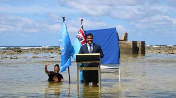 Министр  тонущего  государства обратился за помощью, стоя по колено в воде